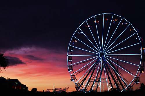 ferris wheel silhouette photography of lit-up ferris wheel during golden hour amusement park